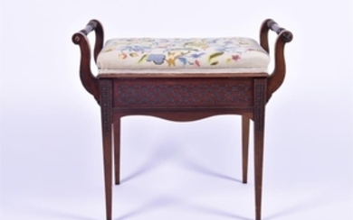 An Edwardian piano seat with turned side handles and hinged lid with tapestry seat, a foliate design to the frieze on all...