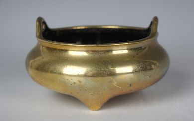 A Chinese polished bronze tripod censer, mark of Xuande but Qing dynasty, of circular bombé for