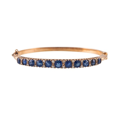 A DIAMOND AND SAPPHIRE BANGLE, the oval sapphires set betwee...