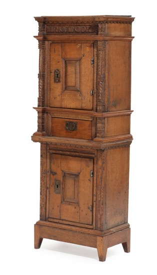 A Danish 17th century Renaissance oak cabinet. Front with two doors and a drawer. Carved with biblical quote. H. 143. W. 53. D. 33 cm.