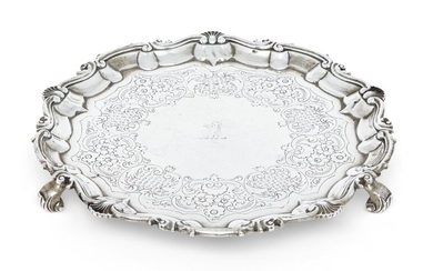 A George III silver salver, London, 1804, William Frisbee, of shaped circular form with shell and scroll border, the later decorated base with crest to centre and raised on three scroll feet, 25cm dia., approx. weight 18.7oz
