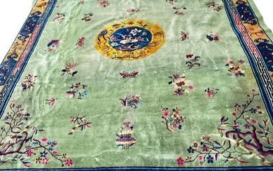 A LARGE DECORATIVE CHINESE CARPET with green ground and...