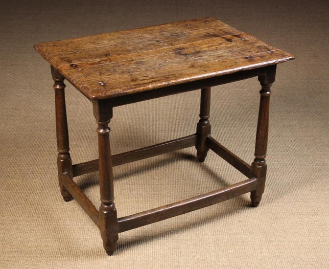 A Late 17th/Early 18th Century Centre Table. The planked top with bevelled ends standing on turned c
