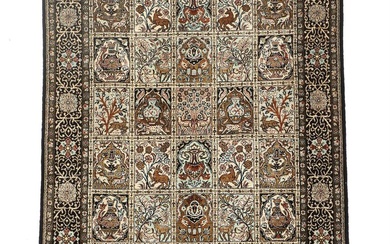 A Persian 20th century Qum silk rug, decorated with animals, flowers and...