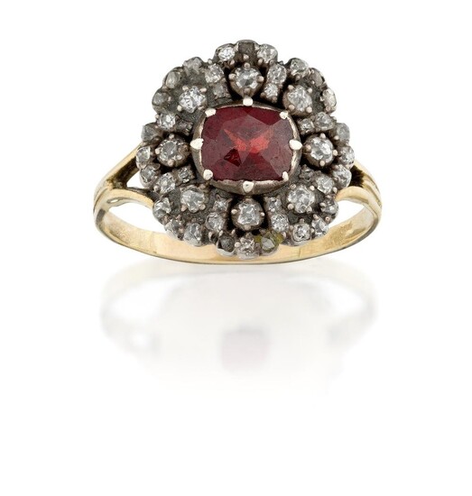 A Victorian garnet ring, the central silver mounted faceted garnet with old-mine-cut diamond cluster surround to later bezel reverse and hoop, approx. ring size O