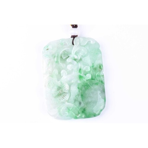 A carved jade pendant, the rounded rectangular panel carved ...