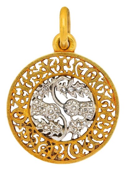 A late 19th early 20th century gold, platinum and diamond pendant, of circular open work design centring on a rose-cut diamond set thistle, encircled by an open work motto in Lombardic script, French assay marks.