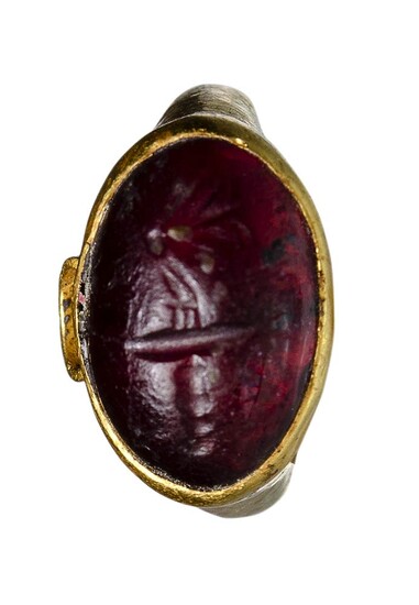 A late hellenistic gold ring with garnet intaglio. Butterfly...