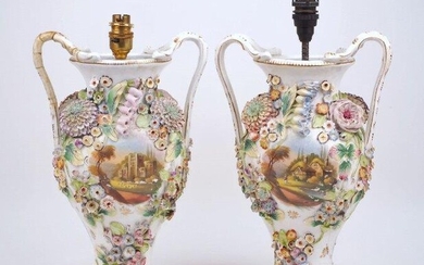 A pair of Continental floral encrusted twin handle vases, 20th century, each with a central painted pastoral scene to the body, with fittings for electricity, 35cm high (excluding electrical fittings) (2) It is the buyer's responsibility to ensure...