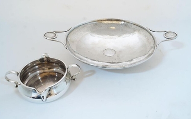 A planished silver twin handled shallow bowl, Birmingham, 1917, Albert Edward Jones, with inset George III coin to centre and two Queen Anne coins inset to handles, on circular foot, numbered 663 to underside, 25.9cm wide; together with a late...
