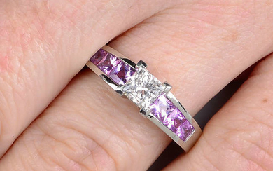 A platinum diamond single-stone ring, with square-shape pink sapphire line gallery and shoulders.