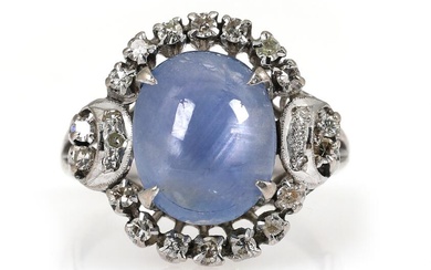 A sapphire and diamond ring set with an cabochon star sapphire encircled...