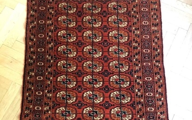 SOLD. A semiantique Bochara rug, Turkmenia. A classical all over design with Güls on a...