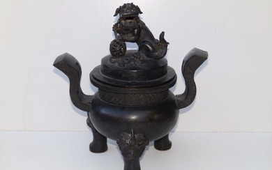 An antique Chinese bronze covered censer, the cover surmounted...