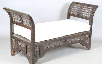 An early 20th century Middle Eastern softwood daybed, similar to those retailed by Liberty & Co