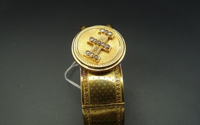 Bracelet Jonc plat semi-rigide en or jaune 18K (750/oo) à plaquettes articulées, décoré de guillochages...