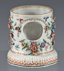 Chinese porcelain watch holder. 18th century. Contoured oval shape applied with garlands of flowers in relief and resting on a gadrooned base, decorated with enamels of the Rose