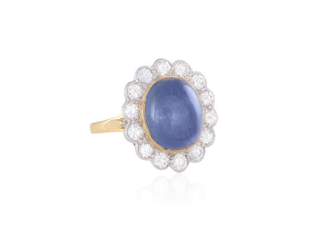 Description A SAPPHIRE AND DIAMOND CLUSTER RING, The oval-shaped...