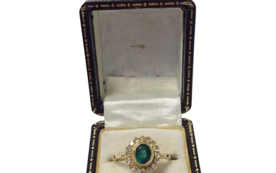 Emerald and diamond cluster ring with an oval mixed cut emerald surrounded by a border of sixteen single cut diamonds in 18ct gold setting, ring size L½.
