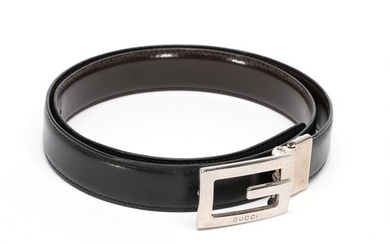 NOT SOLD. Gucci: A black thin belt made of leather with a silver toned logo...