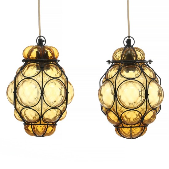 Jacob Eiler Bang: A pair of pendants of amber coloured glass with patinated iron mounting. Manufactured by Holmegaard. H. 28. (2)