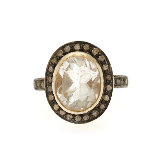 Jewels CPH: A topaz and diamond ring set with a oval-cut white topaz encircled by numerous sinlge-cut diamonds, mounted in sterling silver. Size 52.
