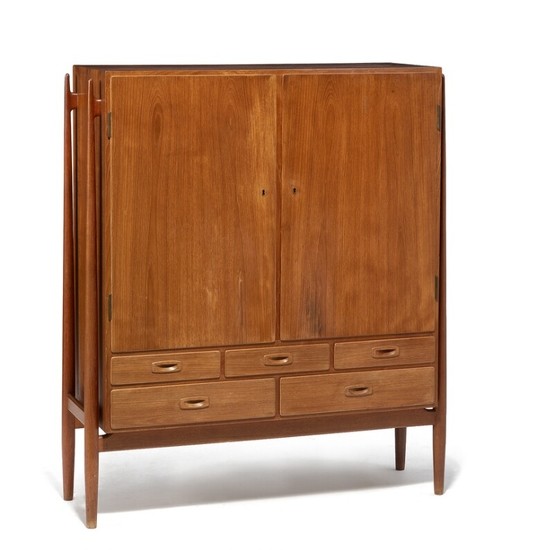 Niels Vodder: Tall teak cabinet mounted on round tapering legs. Front with two doors and five drawers.