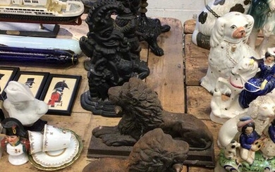 Pair of cast iron lion doorstops, together with a pair of Punch and Judy doorstops, a cast iron stand with lions paw feet and a figurine (6)