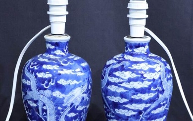 Paire de vases montés en lampe en porcelaine bleue et blanche à décor de dragons...