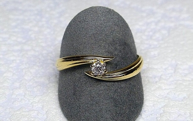 Solitaire or jaune anneau croisé serti d'un diamant taille brillant...