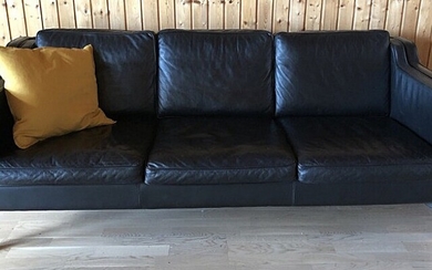Stouby: Freestanding three seater sofa with legs of beech. Sides, back and loose cushions upholstered with black leather. Manufactured by Stouby.