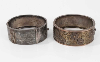 Two Victorian silver hinged bangles, one with applied and textured floral design, Birmingham 1883, the other with engraved scenes depicting various boats in coastal bays