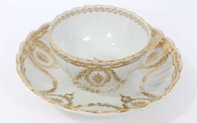 Worcester fluted tea bowl and saucer, circa 1775-80, decorated in gilt with swags and other patterns, the saucer measuring 14cm diameter
