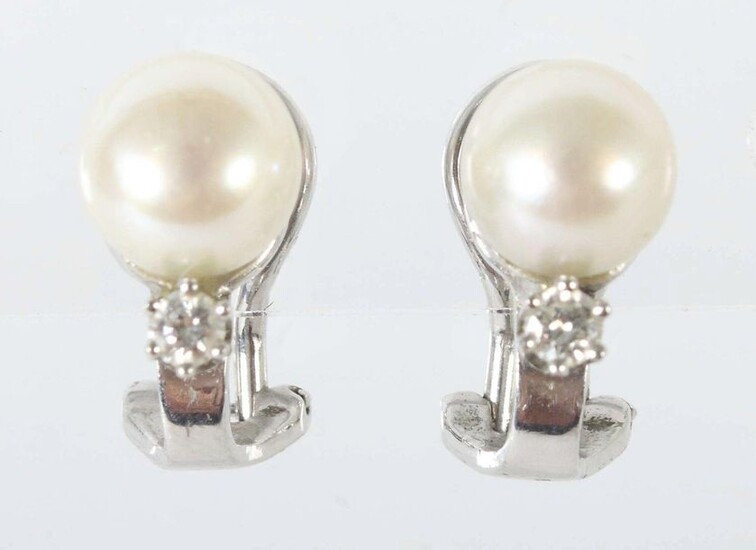 pair of earclips 1980/90's, white-gold 585, set with cultured pearl and one brilliant each (total approx. 0,1 ct), with hallmark of purity, total weight approx. 4,5 g, h: 1,5 cm. Slight signs of wear.