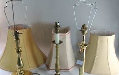 Three modern brass table lamps with shades.
