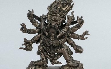 CHINESE SILVERED BRONZE FIGURE OF MAHAKALA WITH HIS CONSORT Mahakala with eight arms and six legs dancing on four prostrate figures....