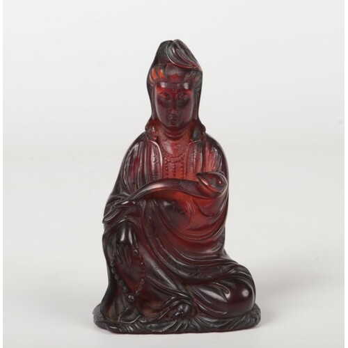 A 19th century Chinese carved amber figure of Guanyin seated...