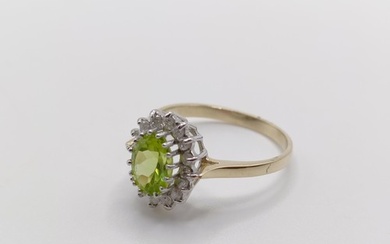 A 9ct yellow and white gold cluster ring, set with an oval-c...