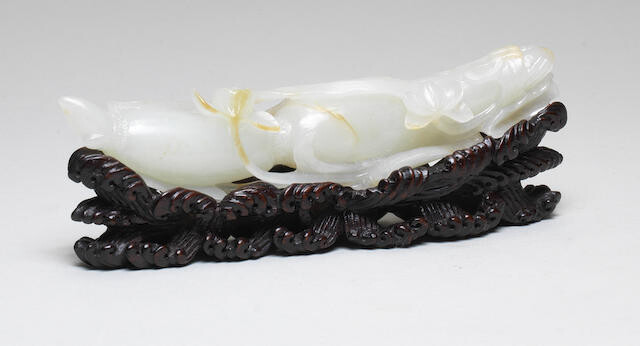 A FINE WHITE AND RUSSET JADE CARVING OF A LOTUS ROOT