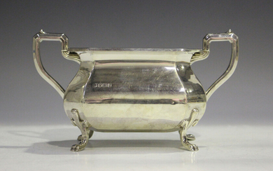 A George V silver two-handled sugar bowl, raised on fleur-de-lis shouldered scroll legs terminating