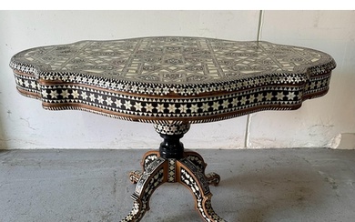 A Moroccan style low pedestal table on splayed legs with geo...