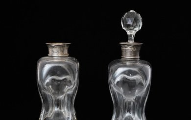 A PAIR OF EDWARDIAN SILVER MOUNTED PINCHED GLASS DECANTERS.