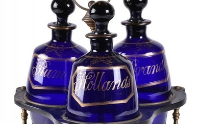 A Regency papier mâché tripartite decanter stand and three blue glass barrel-shaped decanters and stoppers