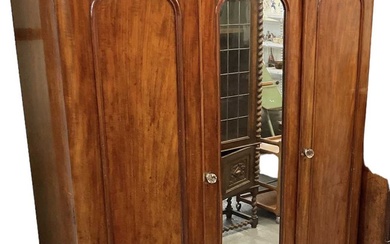 A Victorian mahogany three door wardrobe with central mirrored door,...