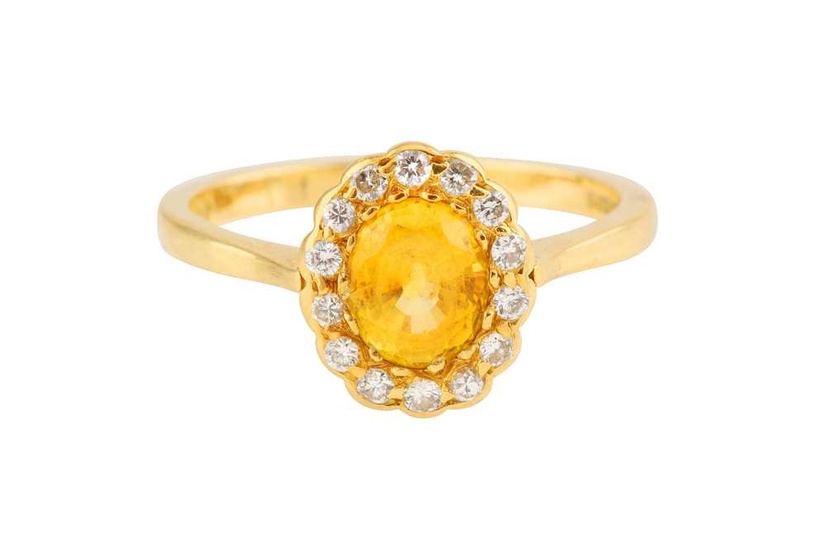 A YELLOW SAPPHIRE AND DIAMOND CLUSTER RING