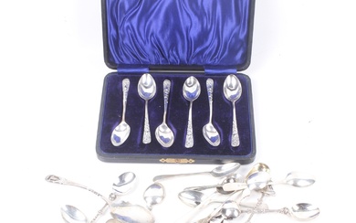 A collection of small silver spoons and a pair of sugar tongs.