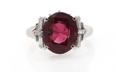 NOT SOLD. A garnet and diamond ring set with an oval-cut garnet flanked by six...
