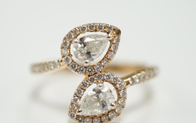 A modern 18k and two stone pear cut diamond set cross-over r...