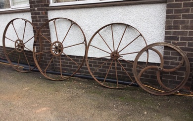 A pair of large iron agricultural wheels, each with eight...