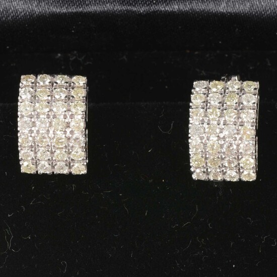 A pair of multi stone diamond hoop earrings.